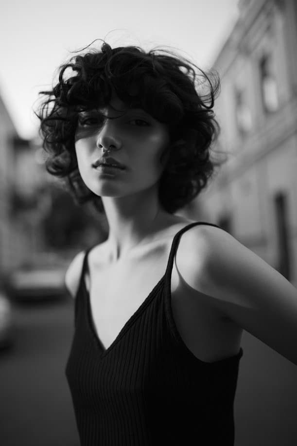 A young woman with short dark curls on a city street